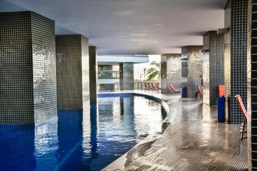 a swimming pool with blue water in a building at Apartamento na Beira Mar de Fortaleza - Edifício Landscape in Fortaleza