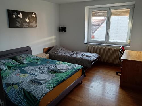 MerxheimにあるMaison villageのベッド2台と窓のある寝室