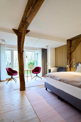 a bedroom with a bed and two chairs and a table at zimmer437 in Varel