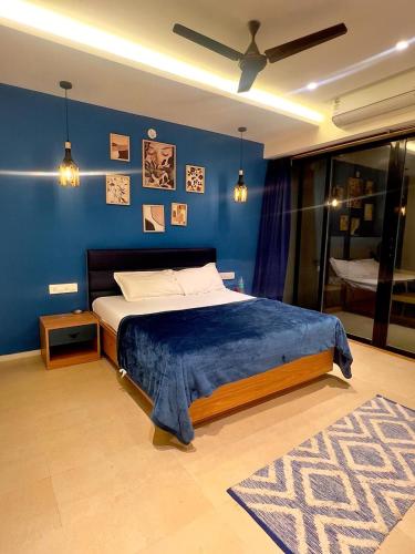 Un dormitorio con una cama con una pared azul. en Yara Villa, en Jāmb
