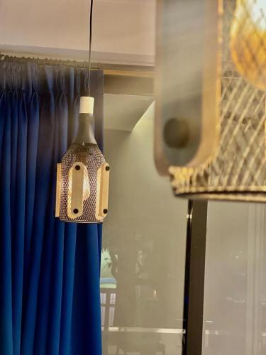 Un comedero para pájaros colgado delante de una cortina azul. en Yara Villa, en Jāmb