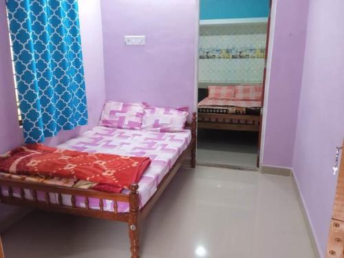 a small bedroom with a bed and a mirror at Shobha home stay in Vattavada