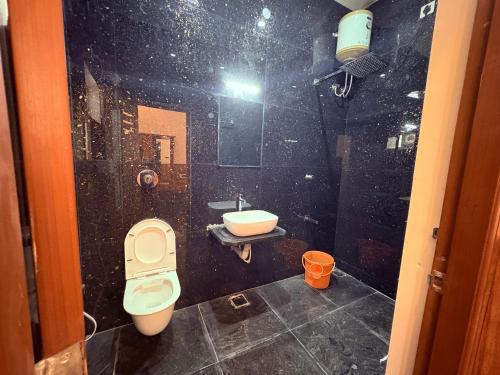 un baño con inodoro y lavabo en Yelagiris Honey Stay, en Yelagiri