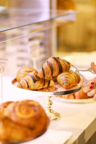 チェゼナーティコにあるGrand Hotel Da Vinciのカウンターの菓子皿を持つ者