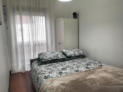 ein Bett mit zwei Kissen darauf in einem Schlafzimmer in der Unterkunft Apartamento T2 in Vila Praia de Âncora