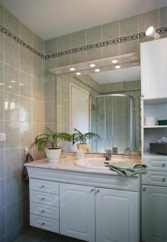 a bathroom with a sink and a large mirror at Marievalerianne in Mirefleurs