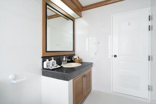 um banheiro com uma pia, um espelho e um chuveiro em Stylish Twin BR w Ensuite Bath & Relaxing Tub BTB7 em Banguecoque