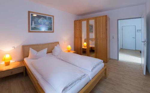 sypialnia z dużym łóżkiem z białą pościelą w obiekcie Brockenblick Ferienpark w mieście Schierke