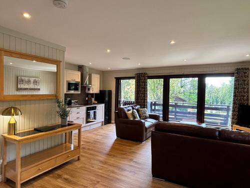 Bluebell Lodge 5 with Hot Tub في نيوتن ستيوارت: غرفة معيشة بها أريكة وطاولة