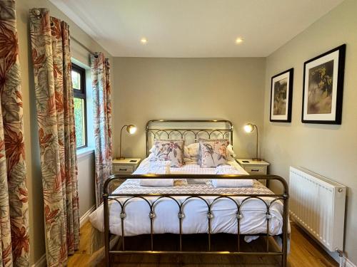 Bluebell Lodge 5 with Hot Tub في نيوتن ستيوارت: غرفة نوم بسرير معدني في غرفة