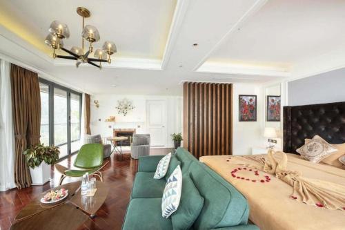 Thang Loi Tam Dao Hotel في تام داو: غرفة نوم بسرير كبير واريكة خضراء