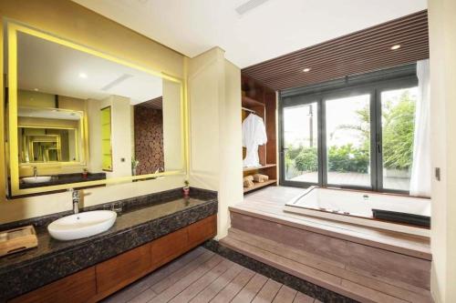 Thang Loi Tam Dao Hotel في تام داو: حمام مع حوض وحوض ونافذة