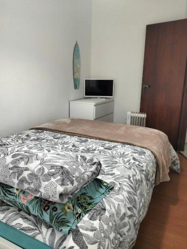 a bedroom with a bed and a tv on a dresser at Apartamento T2 in Vila Praia de Âncora