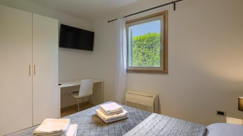 a bedroom with a bed with a window and a desk at Rustic villa Inga with pool and grill in Buje in Kaštel