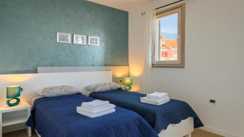 a bedroom with two beds with blue sheets and a window at Rustic villa Inga with pool and grill in Buje in Kaštel