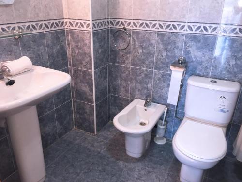 a bathroom with a toilet and a sink at Ibersol Larimar Apartments in Salou