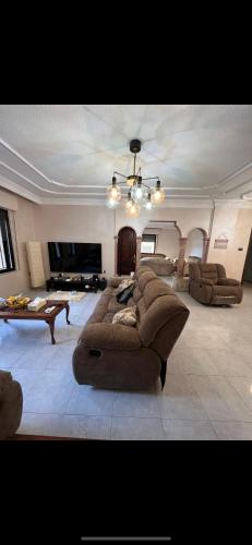 una gran sala de estar con un gran sofá y mesas. en ardan, en Amán