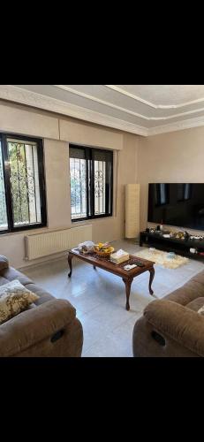 Una sala de estar con una mesa de centro y un sofá en ardan, en Amán