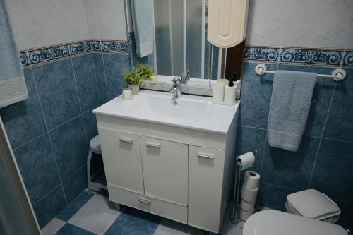 une salle de bains avec un lavabo blanc et des toilettes dans l'établissement Casa da Praia - Vista Mar, à Ericeira