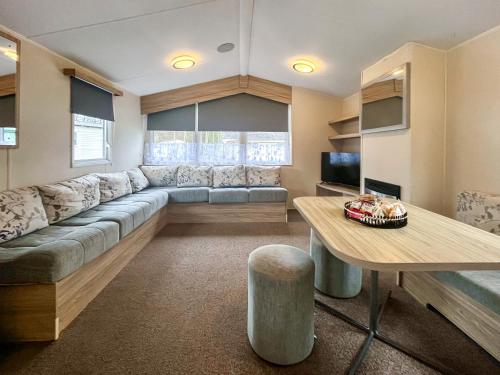 a large living room with a couch and a table at Jordana Lodge in Edzell