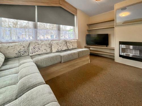 a living room with a couch and a flat screen tv at Jordana Lodge in Edzell
