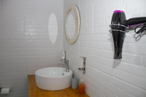 a white bathroom with a sink and a mirror at Moxwini Self Catering Apartments in Maun