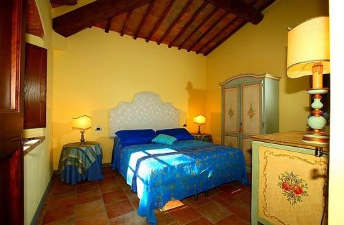 ein Schlafzimmer mit einem blauen Bett in einem Zimmer in der Unterkunft Podere Lucignano Secondo Agriturismo in Gaiole in Chianti
