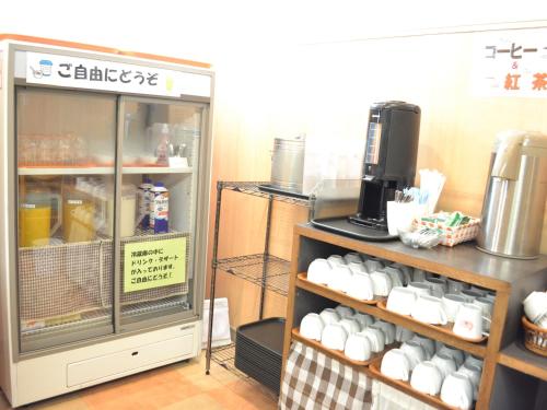 a coffee shop with white cups on a shelf at Hotel Crown Hills Koriyama in Koriyama