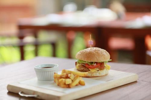 a hamburger and french fries on a cutting board at Le Sen Boutique Hotel in Luang Prabang