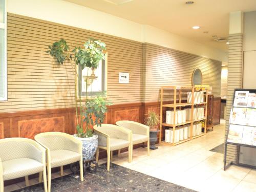 郡山市にあるホテルクラウンヒルズ郡山の椅子と壁に本が置かれた待合室