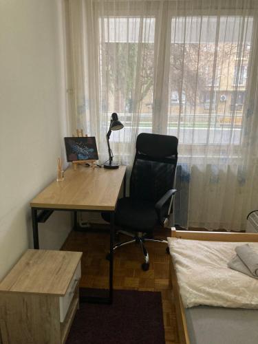 a desk and a chair in a room with a window at Apartmani Vesna in Banja Luka