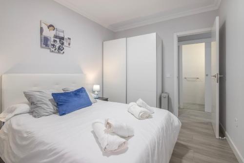 Un dormitorio con una cama blanca con toallas. en Grey House, en Huelva