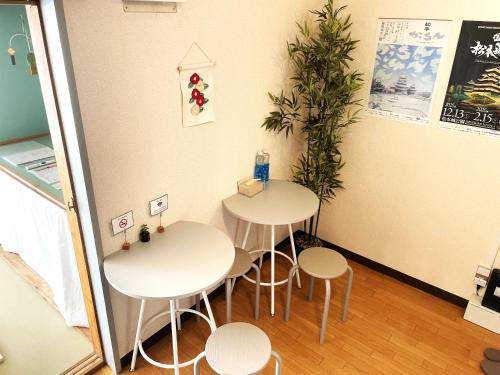 two tables and two stools in a room at cotomaro 305 -Apartment Stay Near Matsumoto Castle- in Matsumoto