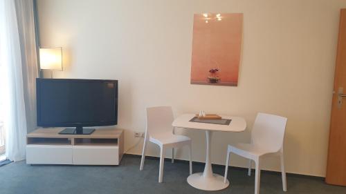 ein Wohnzimmer mit Fernseher und Tisch und Stühlen in der Unterkunft home31 in Hemmingen