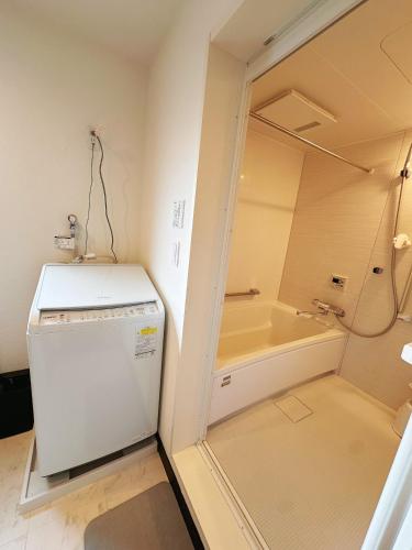a laundry room with a refrigerator and a tub at 阿久津ハイツ201 in Tokyo