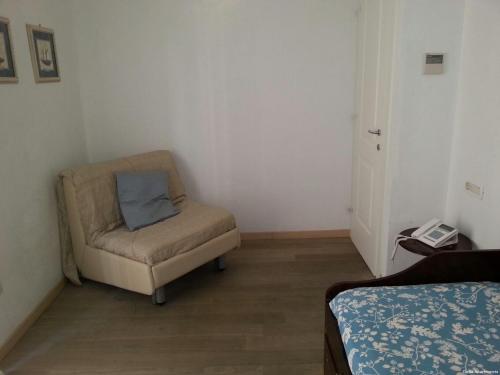 a small room with a chair and a bed at Clelia Apartments - Deiva Marina in Deiva Marina