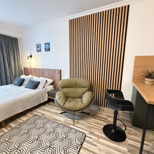a bedroom with a bed and a chair and a desk at EVIS LTD apartments Gudauri in Gudauri