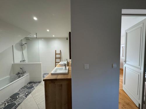 ein Badezimmer mit Waschbecken, Badewanne und Spiegel in der Unterkunft Villa Harmonie in Monteton