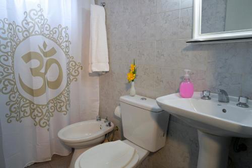 a white bathroom with a toilet and a sink at San Rafael Group in San Rafael