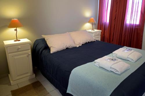 a bedroom with a bed with towels on it at San Rafael Group in San Rafael