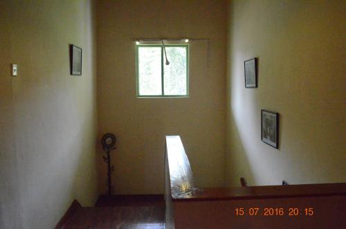 a living room with a window and a stair case at Samri Holiday Bunglow in Nuwara Eliya