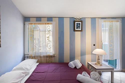 een slaapkamer met een paars bed en een raam bij 5 Terre - Lerici - Piccolo Golfo in Lerici