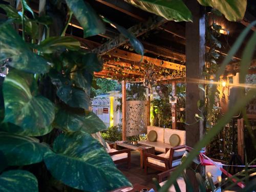 Un patio con mesas de madera y una planta. en Angel Hotels, en Lagos