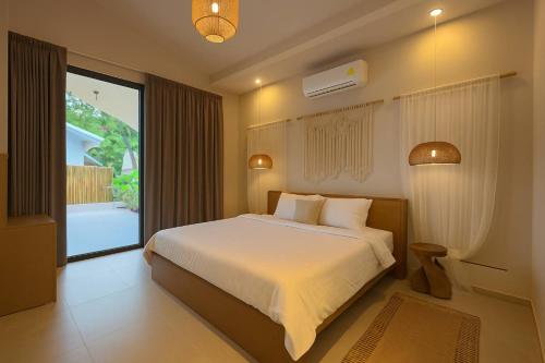 a bedroom with a bed and a large window at Cocolane Villa 2 in Ban Madua Wan