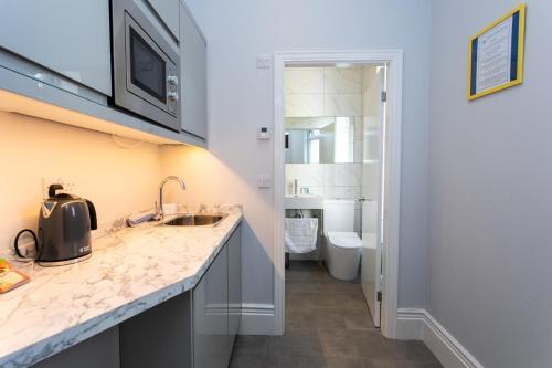 Vacant Nests The linden Hotel Seaside Resort في وايتلي باي: حمام مع حوض ومرحاض