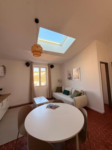 a living room with a table and a skylight at Jolie T2 dans le centre ville Aubagne in Aubagne