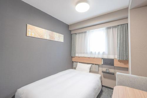 a small bedroom with a bed and a window at R&B HOTEL NAGOYA SAKAE HIGASHI - Vacation STAY 14030v in Nagoya