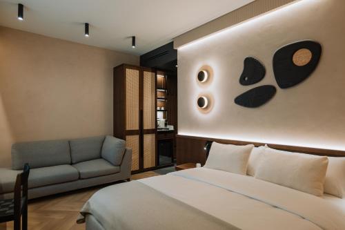 ブカレストにあるホテル トリアノンのベッドとソファのあるホテルの部屋