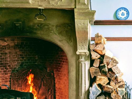 Chateau isigny "Boutique" & Séjour Romantique & Charme في Isigny-le-Buat: موقد من الطوب مع النار فيه