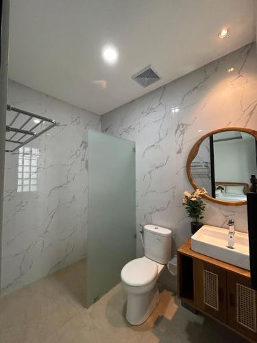 a bathroom with a toilet and a sink at Kariarta Homestay in Cemagi